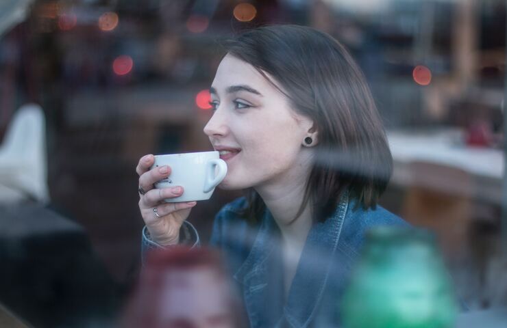 ragazza beve caffè al bar